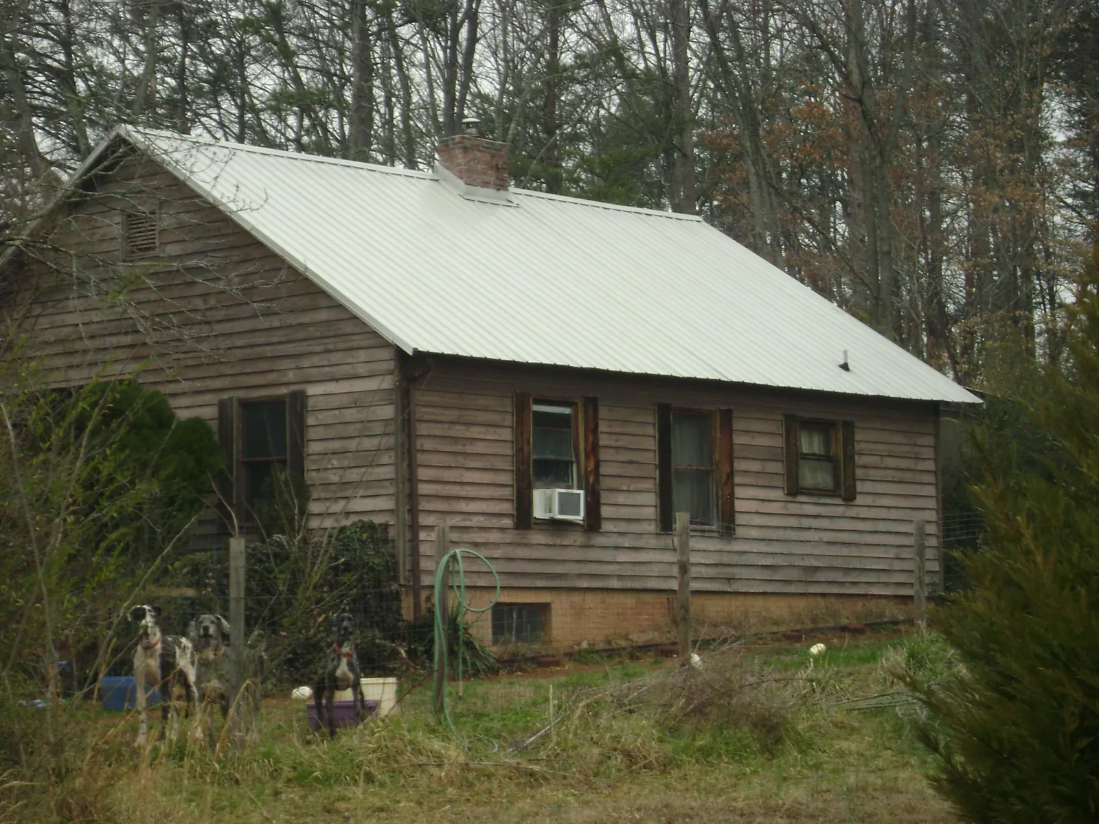 White metal roof on an old wood sided farmhouse, from a Metal Roof Installation job in Custer City